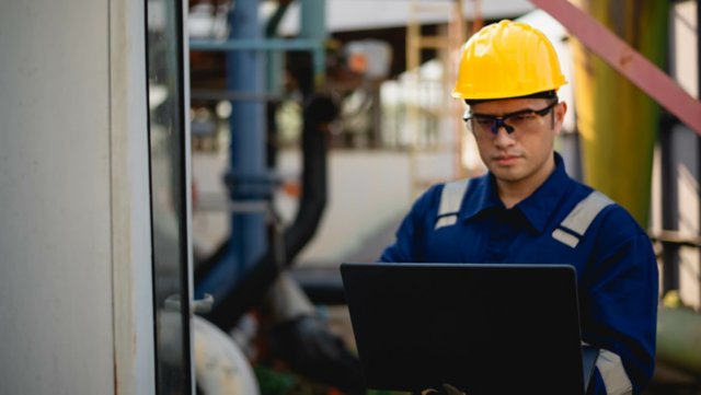 A plumbing inspector is inspecting the operation of a high-pressure water pump system in an industrial plant to ensure compliance with required standards.